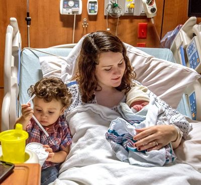 Kristine Cortes lies in her hospital bed with her 18-month-old son, Levi Cortes, and her newborn son, Mikah Cortes, who was born on the leap day Monday, Feb. 29, 2016 at Sentara RMH Medical Center in Harrisonburg, Va. (Austin Bachand/Daily News-Record via AP)