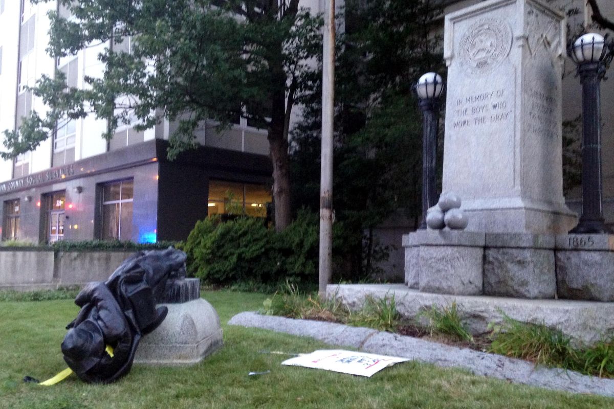 A toppled Confederate statue lies on the ground on Monday, Aug. 14, 2017, in Durham, N.C. Activists on Monday evening used a rope to pull down the monument outside a Durham courthouse. The Durham protest was in response to a white nationalist rally held in Charlottesville, Va, over the weekend. (Jonathan Drew / Associated Press)
