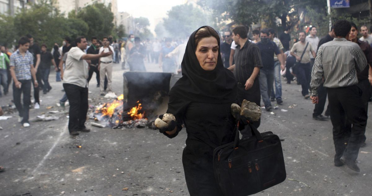 In this June 20 photo posted online, an Iranian woman carries rocks at an anti-government protest in Tehran. (Associated Press / The Spokesman-Review)