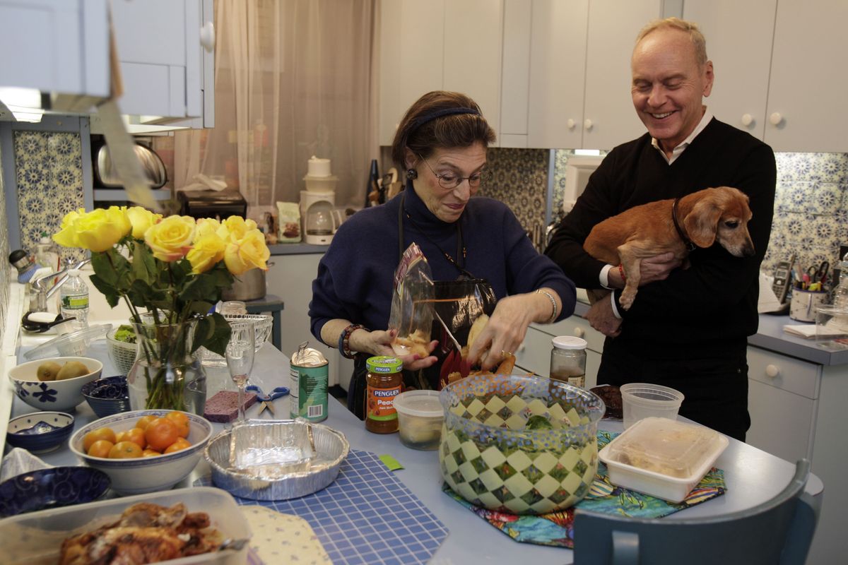 Karen Nelson, and her house guest Gregory Downer, holding his dashund Ziggy, prepare dinner in her upper west side apartment, in New York, Thursday evening, Nov. 1, 2012. Like herself, her neighbors have taken in dozens of "refugees," people who have fled their cold, dark homes in search of a roof, food, a hot shower and juice for their cell phones, iPads and laptops. (Richard Drew / Associated Press)