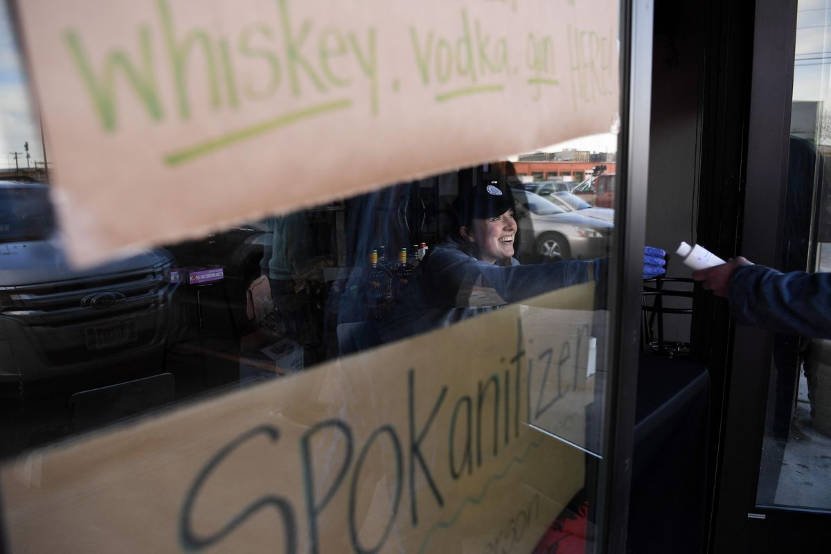 Alexandra Tallas, left, a bartender at Dry Fly hands out Spokanitizer, the company