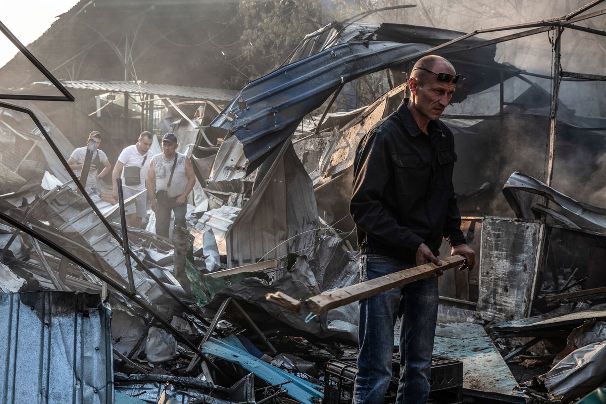 Men try to clear debris at the site of a missile strike on a market in the eastern Ukrainian city of Sloviansk on Sunday. Six people were reported killed and 15 injured in numerous attacks. MUST CREDIT: Photo for The Washington Post by Heidi Levine  (Heidi Levine/For The Washington Post)