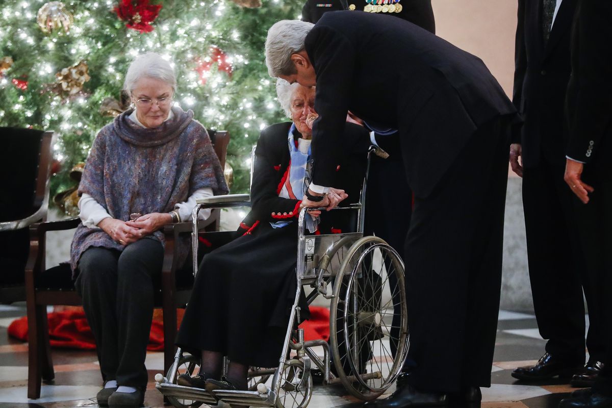 Annie Glenn holds the hand of U.S. Secretary of State John Kerry as her husband John Glenn lies in honor at the Ohio Statehouse rotunda, Friday, Dec. 16, 2016, in Columbus, Ohio. (John Minchillo / Associated Press)