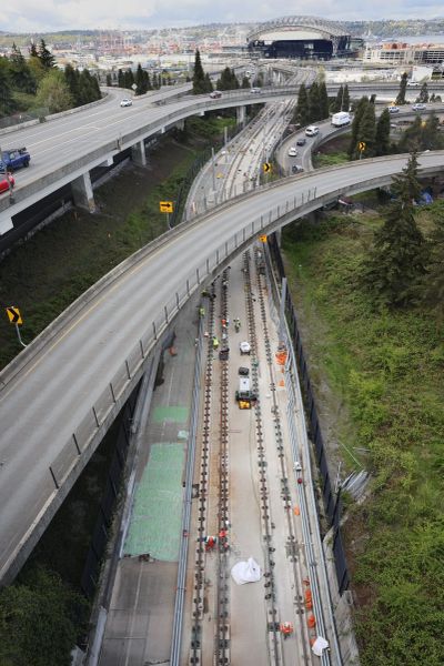 Workers remove concrete track supports, known as plinths, that must be rebuilt in the former Interstate 90 express lanes between Seattle and Bellevue in 2022. Sound Transit is expected to advance $56 million for contractors to keep working until 2025.  (Ellen M. Banner/Seattle Times)