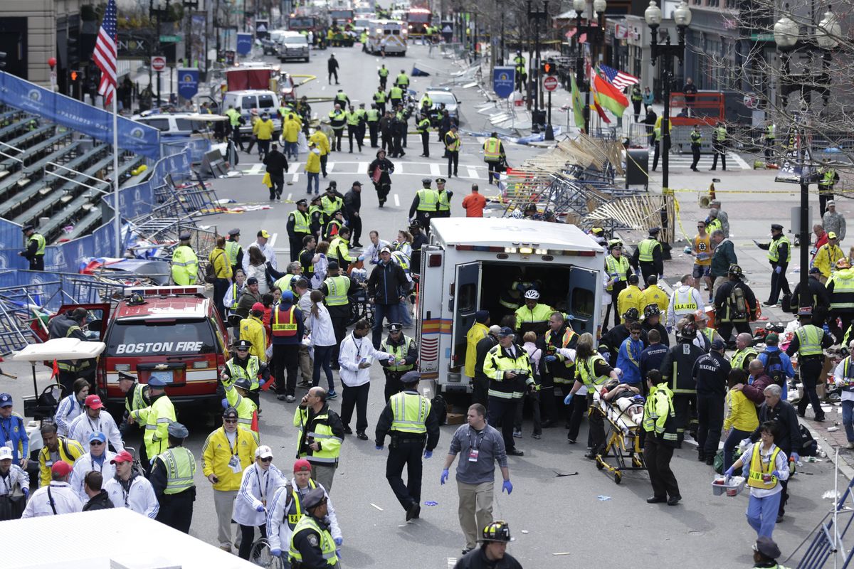 FILE— In this Monday April 15, 2013 file photograph, emergency workers aid injured people at the finish line of the 2013 Boston Marathon following two explosions in Boston. Mass. Boston is marking eight years since the bombing at the 2013 Boston Marathon killed three people and injured scores of others. Acting Mayor Kim Janey on Thursday, April 15, 2021, paid a noontime visit to the downtown memorial marking the bombing site.  (Charles Krupa)