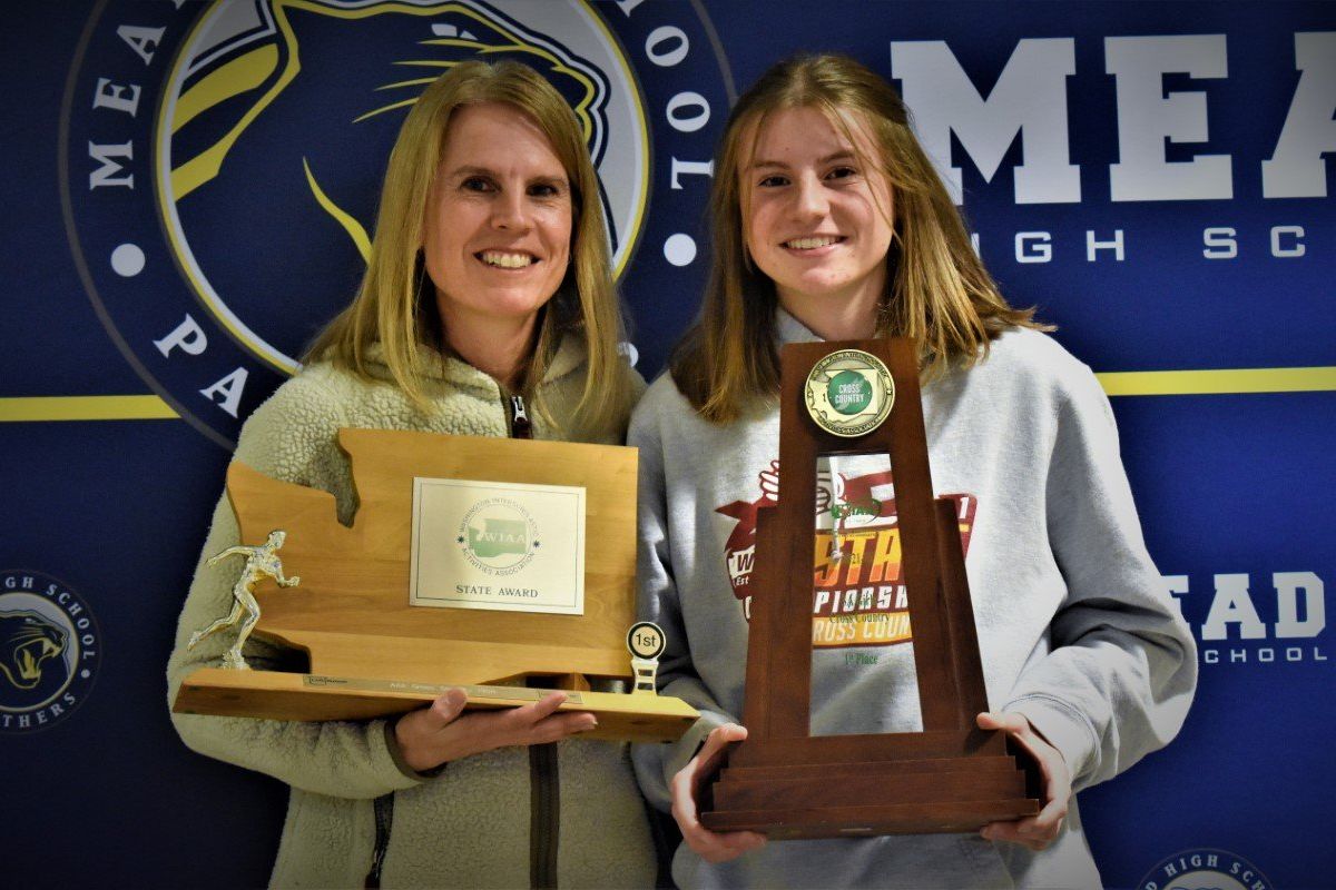 Susan Osborn, left holds the 1988 State 3A girls cross country team trophy, while her daughter, Courtney Osborn, holds the 2021 State 3A trophy.  (Keenan Gray)