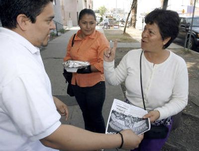 
Jorge-Mario Cabera of the Central American Resource Center, left, gives a march flier to accounting students Angelica Maria Herrera, center, and Alicia Juvera, right, Monday in Los Angeles.
 (Associated Press / The Spokesman-Review)