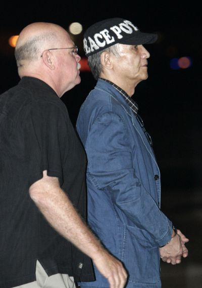 Escorted by Los Angeles police, Kazuyoshi Miura, right,  arrives at Los Angeles International Airport early Friday.  (Associated Press / The Spokesman-Review)