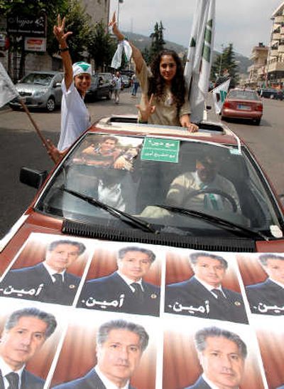 
Supporters  ride in a car bearing pictures of candidate Amin Gemayel in Bikfaya, Lebanon, on Sunday. Associated Press
 (Associated Press / The Spokesman-Review)
