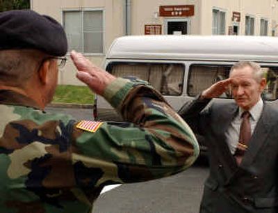 
Accused U.S. Army deserter Charles Robert Jenkins, right, salutes U.S. military police officer Paul Nigara as he surrenders at the U.S. Army's Camp Zama, southwest of Tokyo, to face charges that he left his army unit in 1965 and defected to North Korea, in this Sept. 11 photo.
 (Associated Press / The Spokesman-Review)