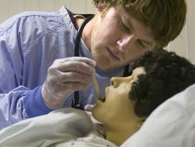 
Nursing student Joel Omlin struggles to get a thermometer correctly placed on a human simulator at the Intercollegiate College of Nursing. Students were working with a computer enhanced patient simulator as they inspect for wounds take vital signs and react to recorded messages from the 