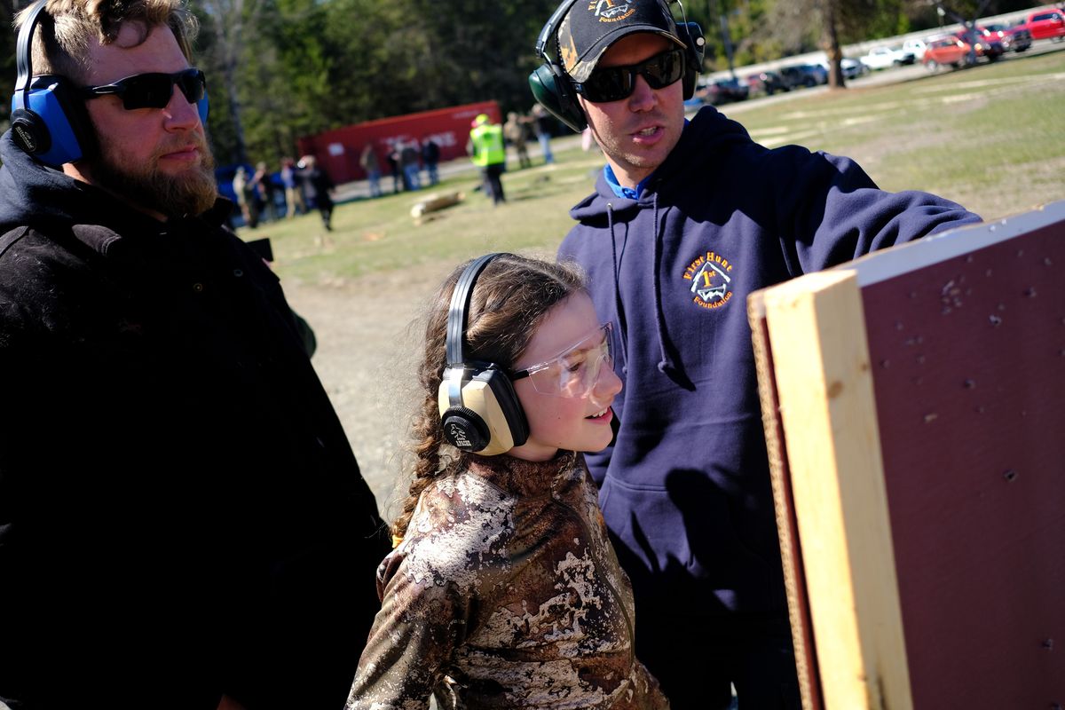 Corinne Holmes, 9, center, checks the pattern on her shotgun with the First Hunt Foundation’s Grant Samsil, right, and her father Josh Holmes, left, during a mentored spring turkey camp for new hunters on Friday, Apr 22, 2022, in Colville, Wash.  (Tyler Tjomsland/The Spokesman-Review)