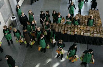 
Employees wait to hand out gift bags at the end of Starbucks' annual shareholders meeting in Seattle this week . Associated Press photos
 (Associated Press photos / The Spokesman-Review)