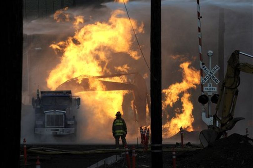 A firefighter keeps his distance as flames engulf an excavator Fifth Street in downtown Lewiston, Idaho, Monday, Nov. 19, 2012, after a gas line was struck. (AP/Lewiston Tribune / Kyle Mills)