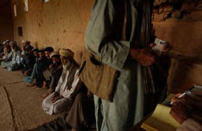 
Afghan men register to vote in their country's first free elections at the voter registration office in Baghe-Alam, 31 miles north of Kabul, Afghanistan, on Sunday. President Hamid Karzai condemned Saturday's bombing in the eastern city of Jalalabad, the bloodiest attack yet in a string of violence targeting election staff, aimed at sabotaging Afghanistan's first free vote, due in September. 
 (Associated Press / The Spokesman-Review)