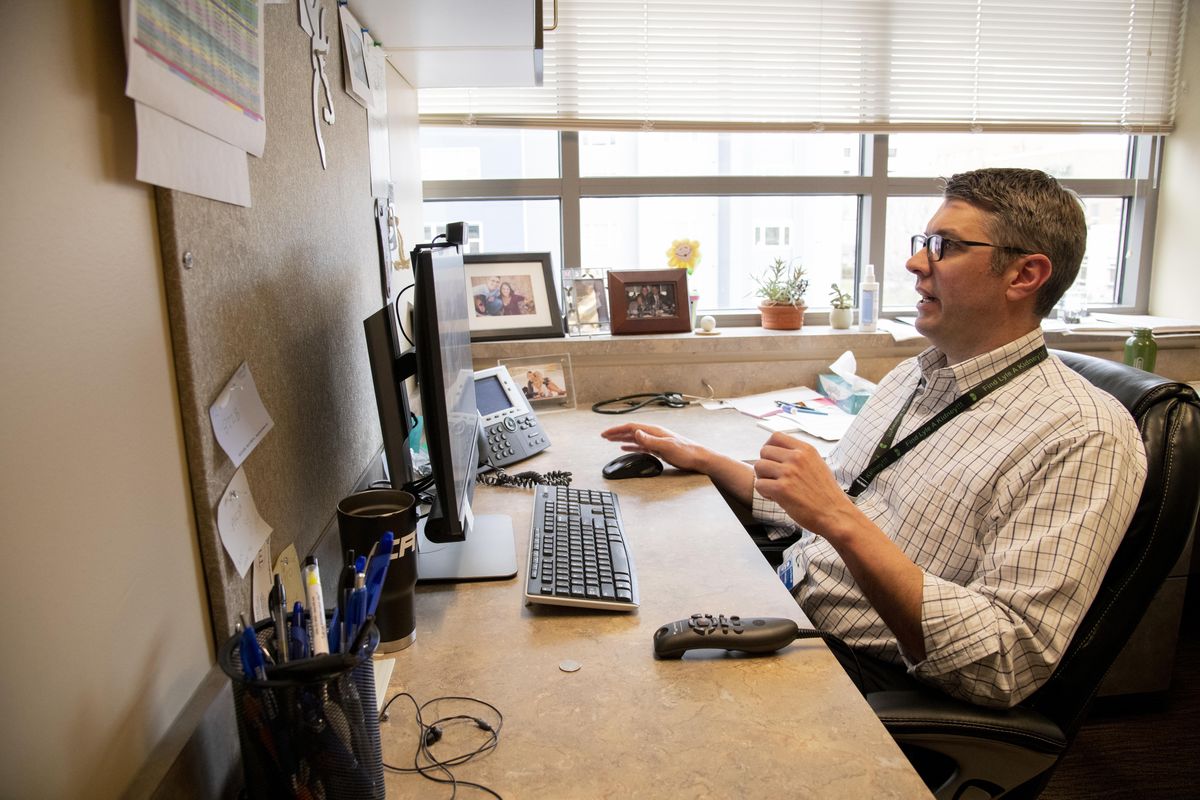 Dr. Soren Olson holds a video appointment with a patient concerning his knee on Monday at Northwest Orthopaedic Specialists in Spokane. At NOS, elective surgeries are postponed, but emergency and urgent surgeries are still performed, and doctors do some follow-up visits in person, although most are via computer. (Jesse Tinsley / The Spokesman-Review)