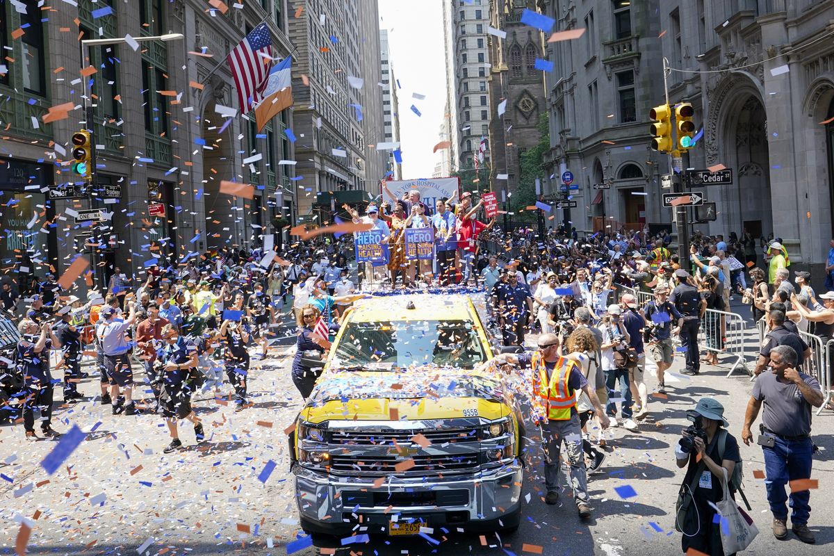 New York City Mayor Bill de Blasio, center, and his wife Chirlane McCray, center left, wave Wednesday from a float during a parade honoring essential workers for their efforts in getting New York City through the COVID-19 pandemic. (Mary Altaffer)