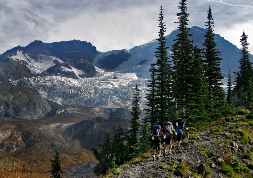 With Mount Rainier in the distance, hikers head toward the Tahoma Glacier on the Wonderland Trail. (Drew Perine)
