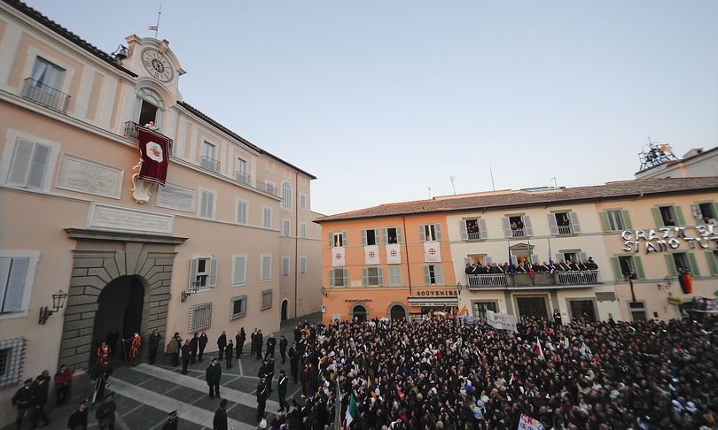 Pope Benedict XVI waves from the balcony window of the Pontifical summer residence in Castel Gandolfo, some 35 kilometers south of Rome, to a cheering crowd gathered to see him the day he ends his pontificate, Thursday, Feb. 28, 2013. (Alessandra Tarantino / Associated Press)