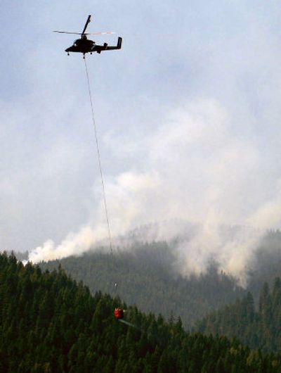 A helicopter dips water from upper Priest Lake on the 160-acre Plowboy fire Sunday. The Plowboy fire is one of five fires burning in the Hughes 32 Complex northwest of Priest Lake. About 1,085 acres have burned since the fire started on Aug. 10. No houses are being affected but crews spent Sunday wrapping the historic Little Snowy Top Lookout tower near Nordman, Idaho. The fire is only 5 percent contained.
(J. BART RAYNIAK / The Spokesman-Review)