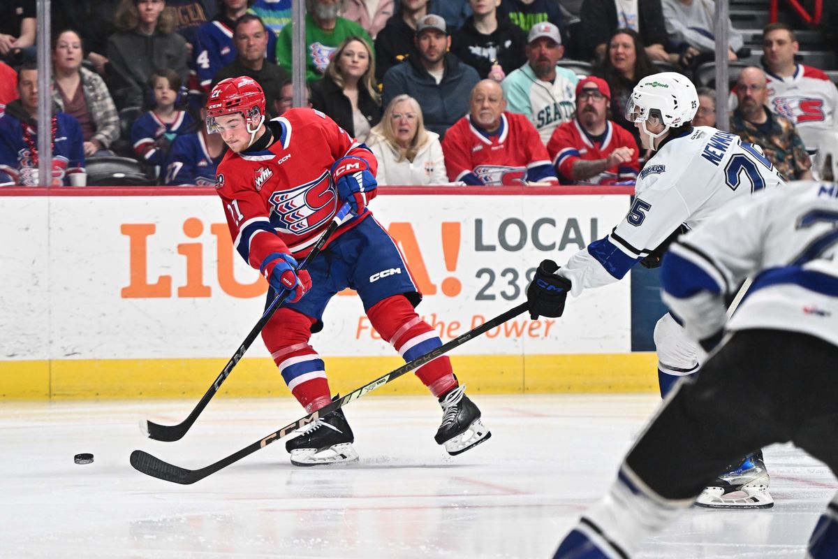 Spokane Chiefs center Owen Martin (21) takes a shot on goal against Victoria Royals right wing Reggie Newman (25) during the Western Conference semi finals on Tuesday, April. 22, 2025 at Spokane Arena in Spokane WA.  (James Snook)