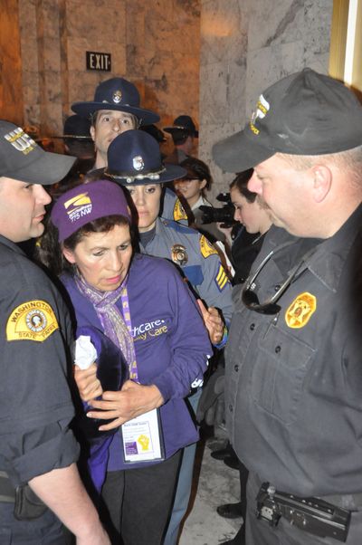 Protester arrested by state troopers outside the Governor's Office during demonstrations over the state budget. (Jiim Camden/The Spokesman-Review)