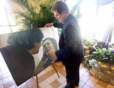 
John Bunnell, funeral director for Gulfport Memorial Funeral Home, places a photo of Terri Schiavo and her mother at the entrance of Most Holy Name of Jesus Catholic Church in Gulfport, Fla., prior to Schiavo's funeral Mass on Tuesday. 
 (Associated Press / The Spokesman-Review)