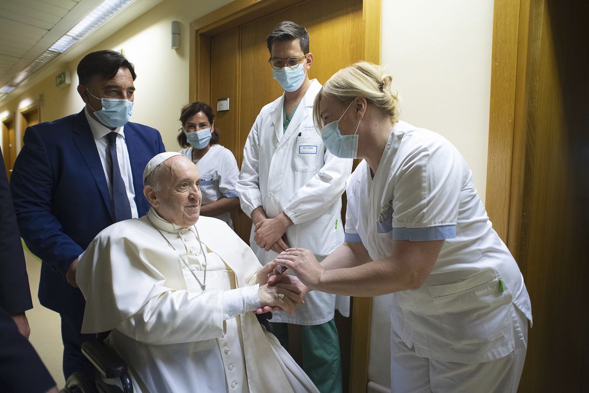 Pope Francis is greeted by hospital staff as he sits in a wheelchair inside the Agostino Gemelli Polyclinic in Rome, Sunday, July 11, 2021, where he was hospitalized for intestine surgery.  (Vatican Media)