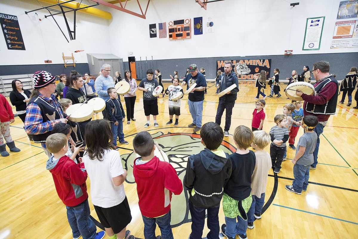 Members of the Canoe Family perform during the Grand Ronde tribal flag posting ceremony at the high school gym in Willamina, Ore., on Nov. 16, 2015. (Marcus Larson / News-register)