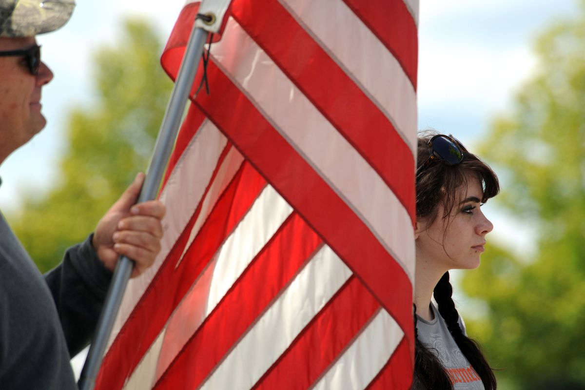 Ashley Moore, 19, watches the procession carrying the body of Spc. Nicholas Newby down Ramsey Road on Friday. Moore dated Newby before he was deployed with his National Guard unit, and her father, Chris, left, used to fish and camp with Newby. (Jesse Tinsley)