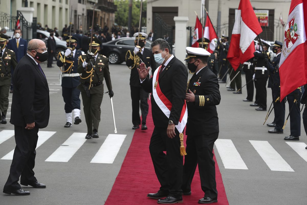A military aide shows the way to Manuel Merino, the head of Peru