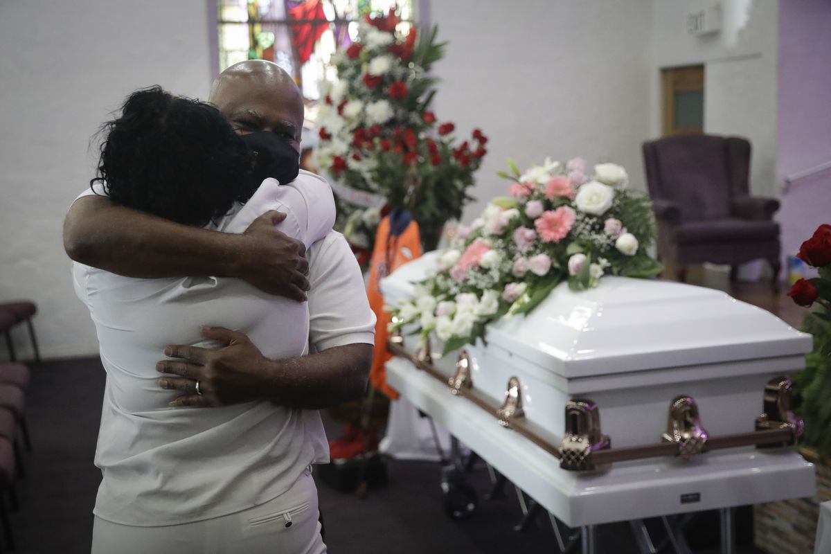 FILE - In this July 21, 2020, file photo, Darryl Hutchinson, facing camera, is hugged by a relative during a funeral service for Lydia Nunez, who was Hutchinson