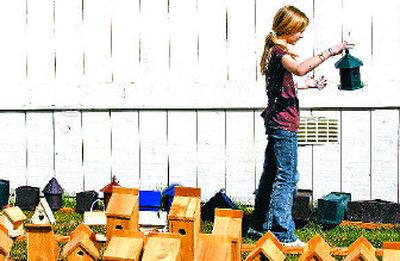 
Hayden Meadows Elementary fourth-grader Whitney Kane looks for a spot for her freshly painted birdhouse at the school in Hayden. 
 (Kathy Plonka / The Spokesman-Review)
