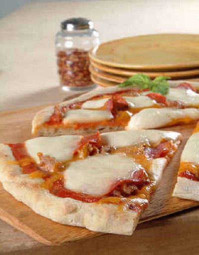 
The Golden Gate Pizza can be a quickly assembled pizza to bake at home, topped with cheddar, salami, sausage and pepperoni, plus mozzarella slices. 
 (Associated Press/California Milk Advisory Board / The Spokesman-Review)