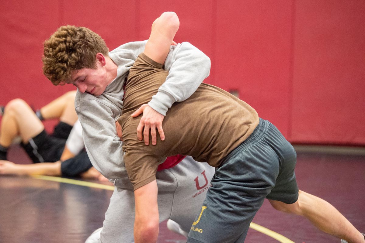 Drew Roberts, left, throws his training partner, Cam Domke, right, during practice Friday, Dec. 21, 2018, at University High School in Spokane Valley, Wash. Domke generally wrestles at 138, while Roberts alternates between 128 and 132 for the University Titans. (Jesse Tinsley / The Spokesman-Review)