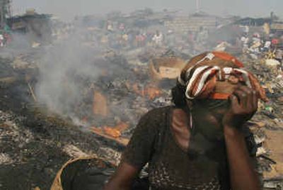 
A vendor covers her face from garbage smoke Thursday in Port-au-Prince, Haiti. 
 (Associated Press / The Spokesman-Review)
