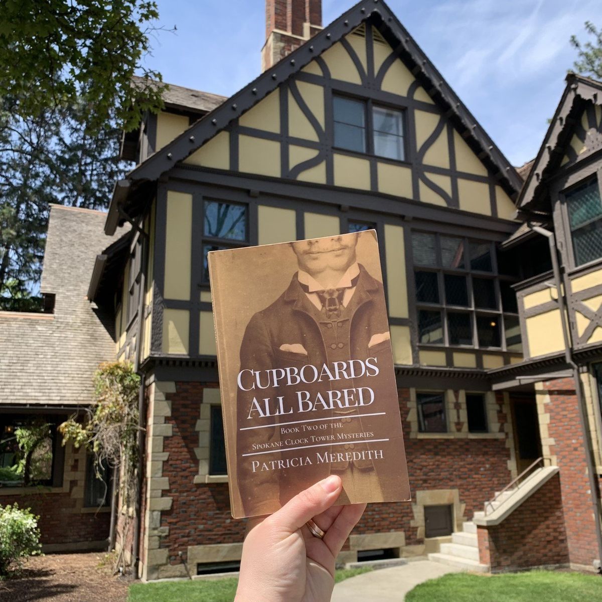 Above: Patricia Meredith holds up her book “Cupboards All Bared” in front of Campbell House.  (Patricia Meredith)