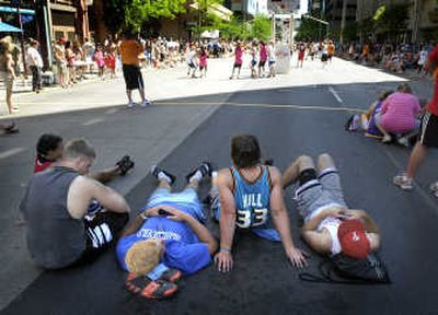 
Danny Engel, of Kennewick, uses his shoes for a pillow as he and teammates Rance Brown,  left,  and Layton Brown  cool off after winning their first game. 
 (CHRISTOPHER ANDERSON / The Spokesman-Review)