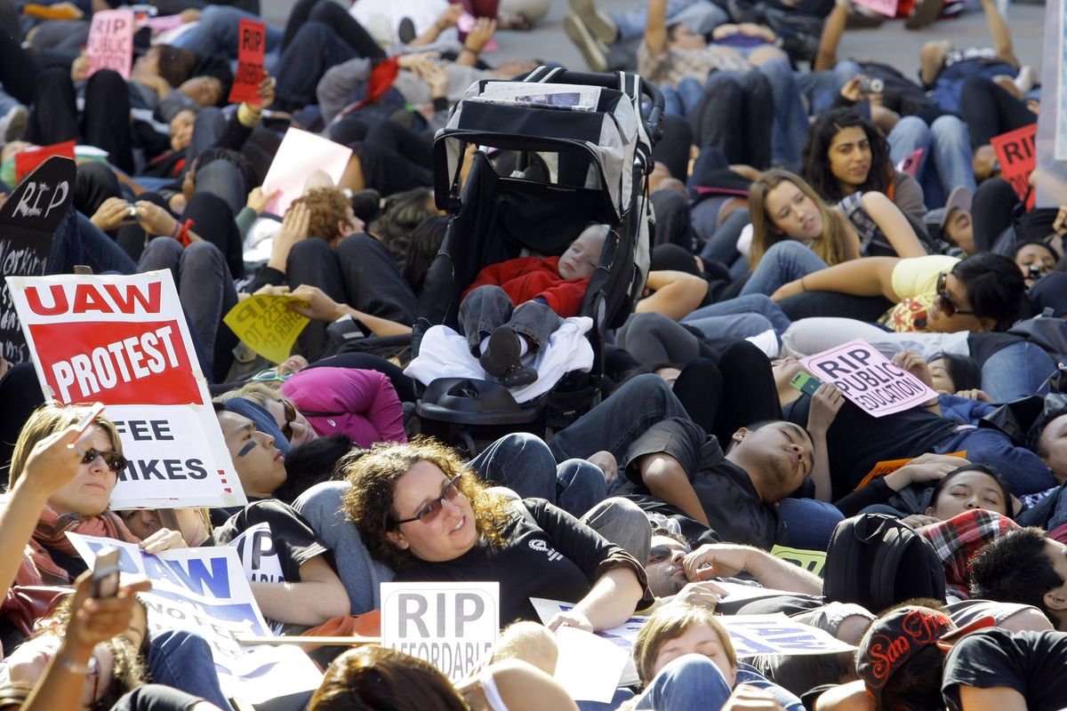 Hundreds of students lay down to symbolize the “death of public education” outside the UCLA campus Covel Commons building on Thursday. Associated Press photos (Associated Press photos)