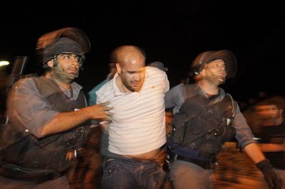 An Israeli demonstrator is arrested during clashes with police  in the northern Israeli town of Acre on Saturday.   (Associated Press / The Spokesman-Review)