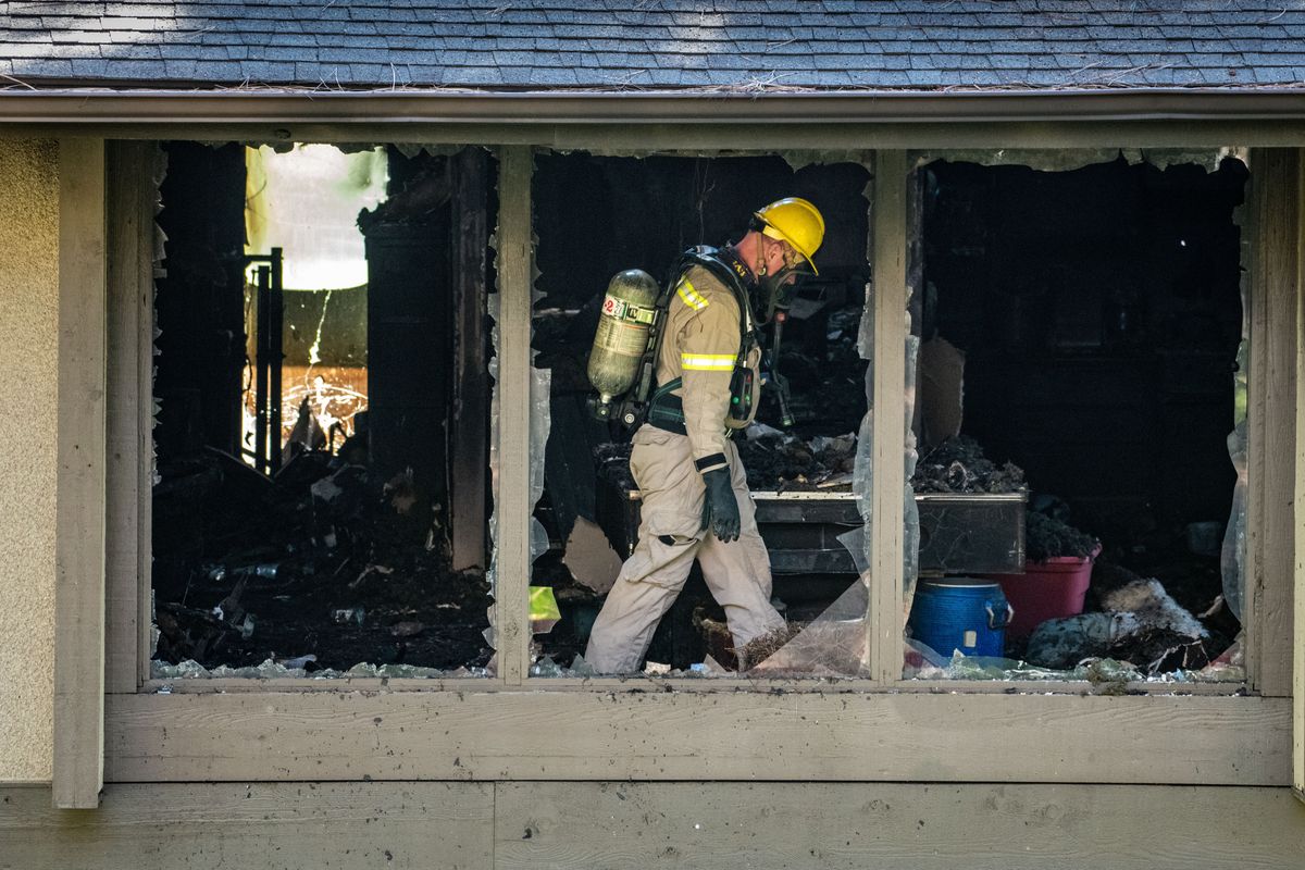 An investigator with Spokane Valley Fire works the interior of an arson-caused apartment fire Monday. A 15-year-old girl was arrested and accused of setting fire to her family’s residence in the Balfourwood Apartments on South Dartmouth Street in Spokane Valley.  (Colin Mulvany/THE SPOKESMAN-REVIEW)