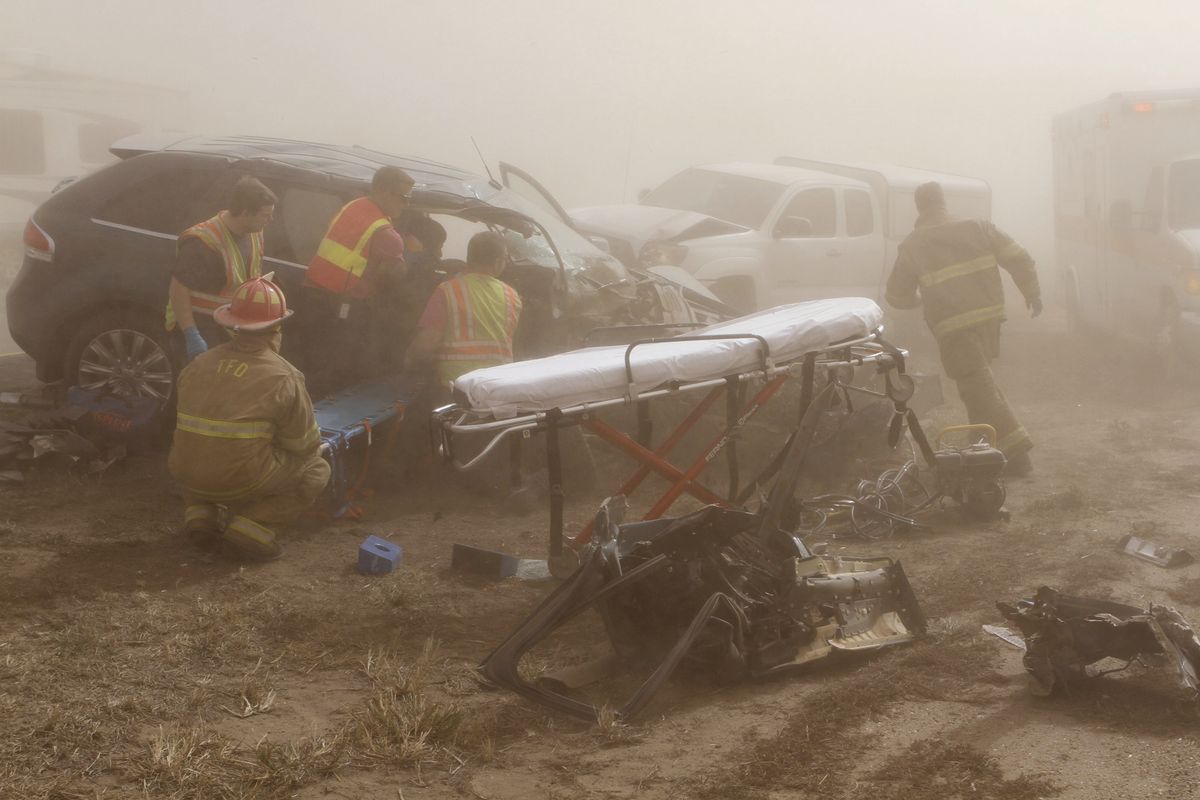 Rescue personnel work to remove a woman pinned in a vehicle after it was involved in an accident on Interstate 35 near Blackwell, Okla., Thursday. A massive dust storm triggered a multivehicle accident. (Rolf Clements photos)
