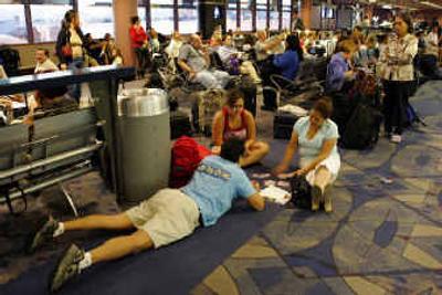 
Passengers play cards as they wait for their flight to Oakland, at McCarran International Airport in Las Vegas, last month. Radio failure at a Federal Aviation Administration control facility forced some airports in the West to hold flights on the ground Tuesday, authorities said. This high-tech foul-up put lives at stake as hundreds of aircraft lost contact when someone failed to reboot the system that handles radio communications with Southern California's air traffic controllers. 
 (Associated Press photos / The Spokesman-Review)