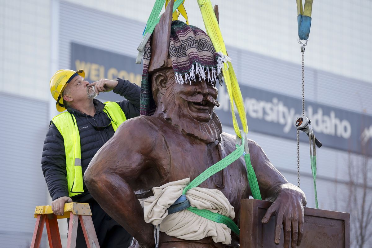 Hiram Davies makes adjustments to rigging Saturday while helping to install a bronze sculpture of Joe Vandal between the ICCU Arena and P1FCU Kibbie Dome in Moscow, Idaho. The bronze sculpture was created by Gareth Curtiss at his foundry in Fortime, Mont. (Geoff Crimmins/For The Spokesman-Review)