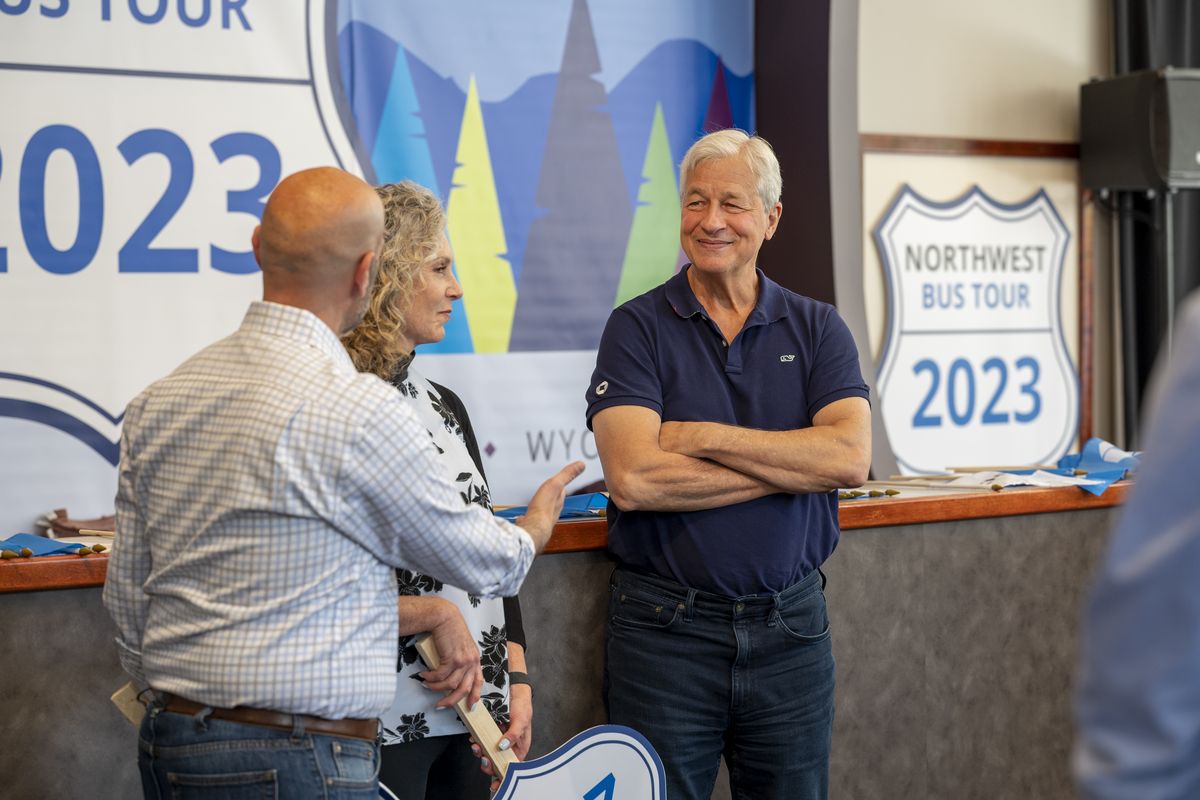 Jamie Dimon, right, talks with Abe Azar, left, and Dorlene Cross, center, of the Spokane branch of Chase bank on July 30.  (Jesse Tinsley/The Spokesman-Review)