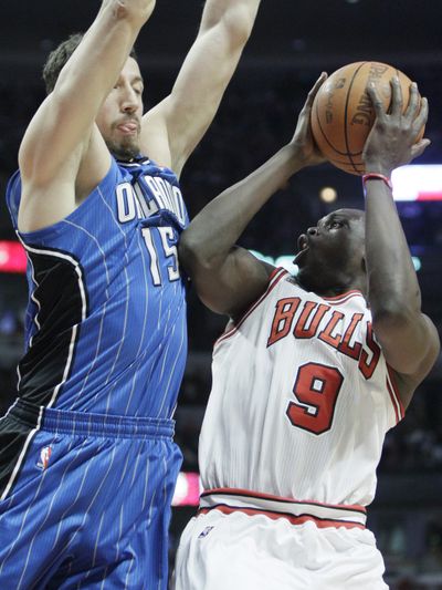 Chicago Bulls’ Luol Deng, right, shoots against Orlando Magic’s Hedo Turkoglu during the third quarter of Chicago’s 99-90 win. (Associated Press)
