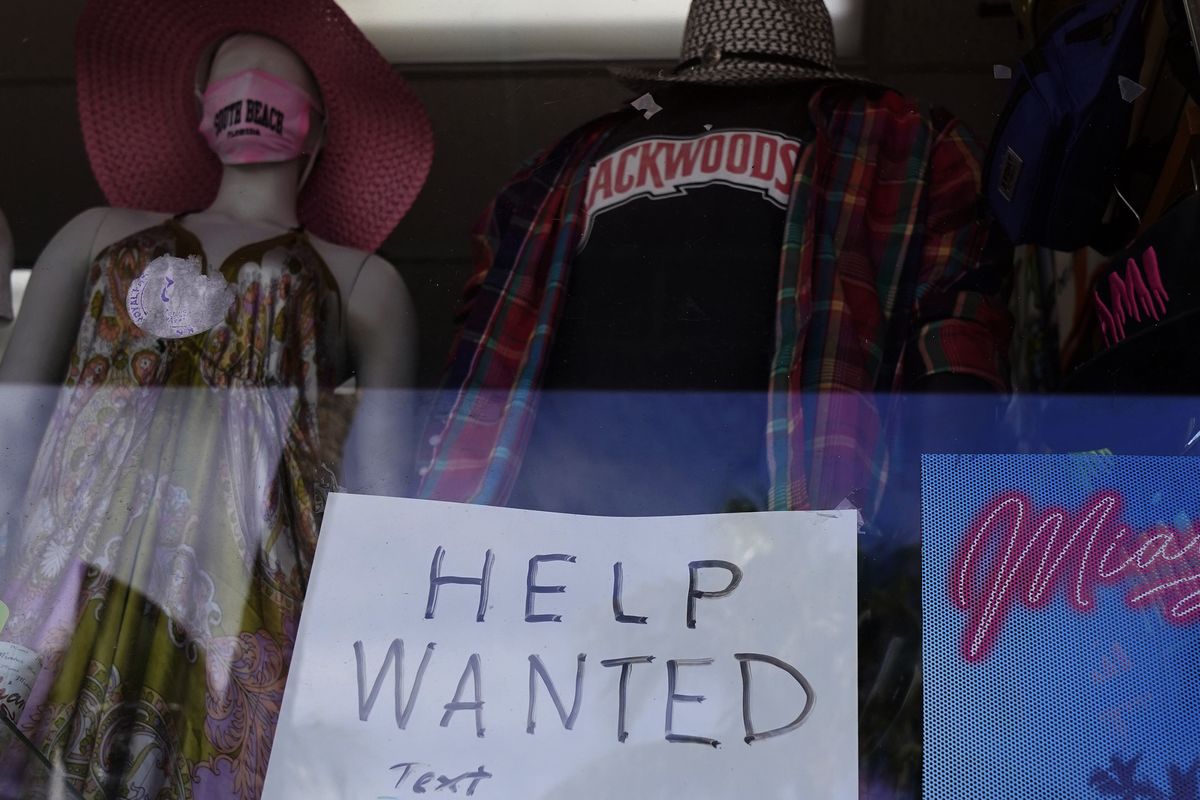 FILE - In this Jan. 7, 2021 file photo, a "Help Wanted," sign is shown in the window of a souvenir shop in Miami Beach, Fla. Hiring has weakened for six straight months. Nearly 10 million jobs remain lost since the coronavirus struck. And this week, the Congressional Budget Office forecast that employment won’t regain its pre-pandemic level until 2024.  (Associated Press)