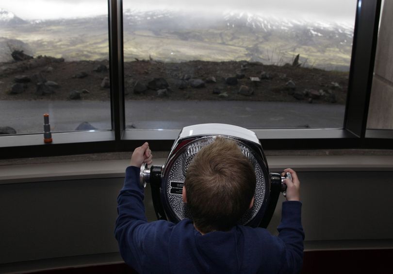 Associated Press Scoping mechanism: Gavin Snow, 7, of Kelso, Wash., uses a viewing scope to get a closer look at Mount St. Helens at the Johnston Ridge Observatory on Tuesday, the 30th anniversary of the volcano’s violent May 18, 1980, eruption. (Associated Press)