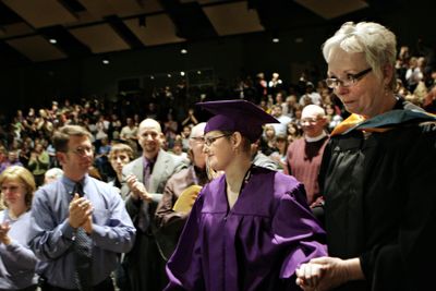 Teacher Jane Wiles helps Liz Evett walk onstage to receive her diploma during a graduation Wednesday in West Richland.  (Associated Press / The Spokesman-Review)