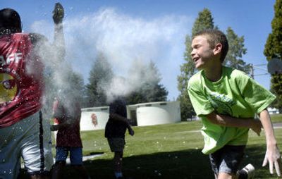 
Dusty Christiansen, 9, throws a flour-covered marshmallow at Northeast Youth Center camp leader Ray Anderson during a 
